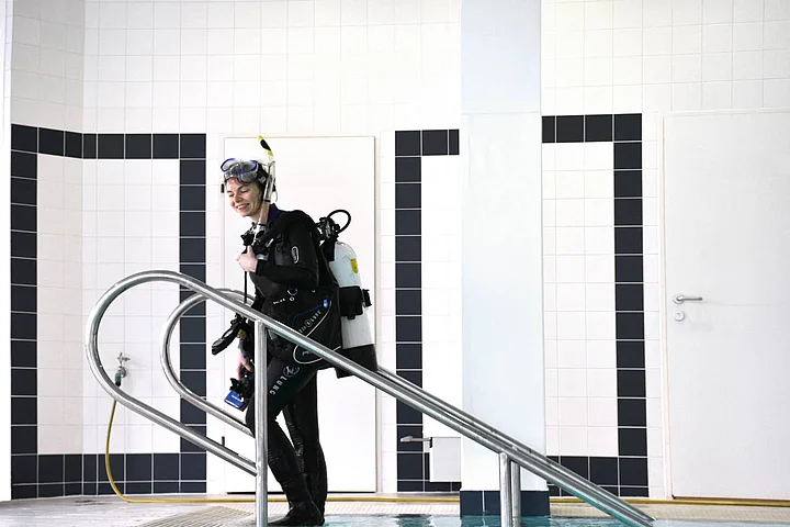 Frau Recla in Tauchausrüstung zur Reinigung Schwimmbad